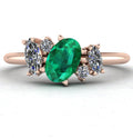 Front view of the Atlantis engagement ring, featuring a bespoke asymmetrical cluster of vivid green emeralds and brilliant white diamonds in 18ct rose gold.