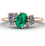 Front view of the Atlantis engagement ring, featuring a bespoke asymmetrical cluster of vivid green emeralds and brilliant white diamonds in 18ct rose gold.