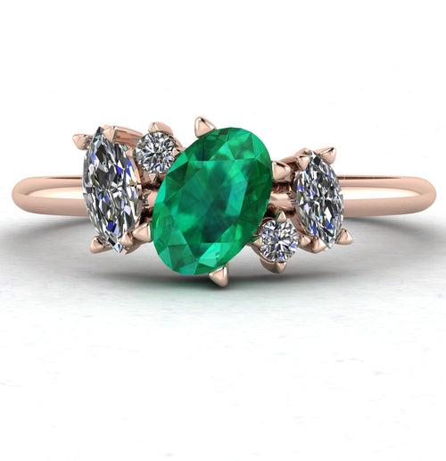 Front view of the Atlantis engagement ring, featuring a bespoke asymmetrical cluster of vivid green emeralds and brilliant white diamonds in 18ct rose gold.