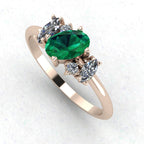 Three-quarter view of a handmade asymmetrical emerald and diamond ring showing the organic rose gold setting.