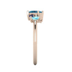 Atlantis London blue topaz and sapphire asymmetrical engagement ring in 18ct rose gold, side profile showing the organic contemporary stone settings and elegant curve of the rose gold band, handmade in our London studio
