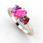 An angled perspective of the Atlantis ring, highlighting how the pink and violet gemstones complement the warm tones of the rose gold band.