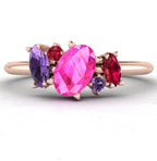 Front view of the Atlantis engagement ring featuring an asymmetrical cluster of pink and violet sapphires with a ruby in 18ct rose gold.