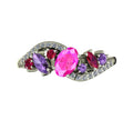 Top view of the Atlantis Storm ring set with a central pink sapphire, violet sapphires, rubies, and white diamonds.