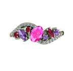 Top view of the Atlantis Storm ring set with a central pink sapphire, violet sapphires, rubies, and white diamonds.
