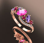 Angled shot of the wave-inspired rose gold setting, highlighting the cluster of rubies, sapphires, and brilliant-cut diamonds.