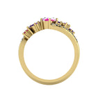 Through-finger view of the yellow gold Atlantis Storm ruby and sapphire ring, showing the hallmark and high-end setting structure.