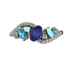Top-down hero shot of the Atlantis Storm white gold ring with a violet-blue tanzanite, zircons, and aquamarines.