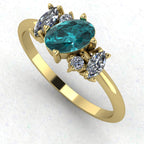 An angled perspective of the Atlantis ring, showcasing the organic, contemporary design and the rich colour contrast of teal sapphires against the yellow gold band.