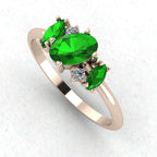 An angled perspective of the Atlantis ring, showcasing the organic, contemporary design and the striking contrast of green garnets against the rose gold band.
