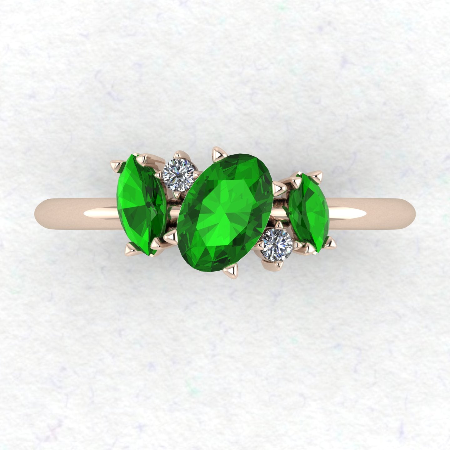 A top-down view of the Atlantis engagement ring, featuring an asymmetrical cluster of vivid green tsavorite garnets and sparkling diamonds in 18ct rose gold.