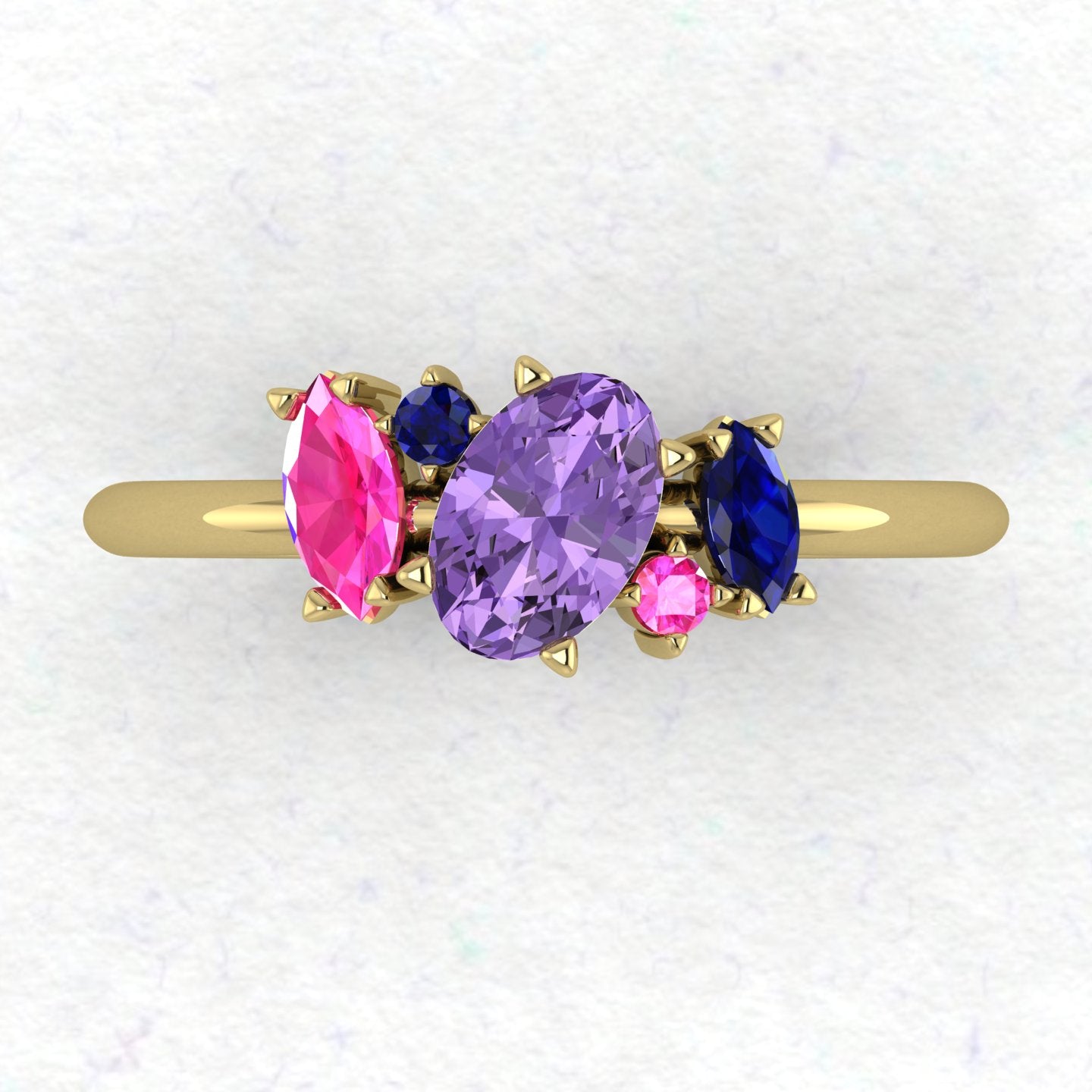 A top-down view of the Atlantis engagement ring featuring an asymmetrical cluster of violet and pink sapphires accented by a ruby in 18ct yellow gold.