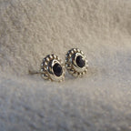 Side view of a silver black spinel stud earring showing the setting height and polished sterling silver post.