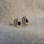 Side view of a silver black spinel stud earring showing the setting height and polished sterling silver post.