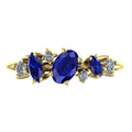 Top view of the Atlantis Paradise ring in 18ct yellow gold, featuring a central blue sapphire and an asymmetrical diamond cluster.