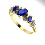 An angled view of the 18ct yellow gold ring highlighting the light interaction with the sapphire and diamonds.