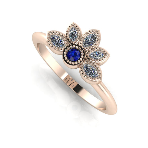 Angled perspective of a blue sapphire and marquise diamond cluster ring in 18ct rose gold with beaded milgrain texture.