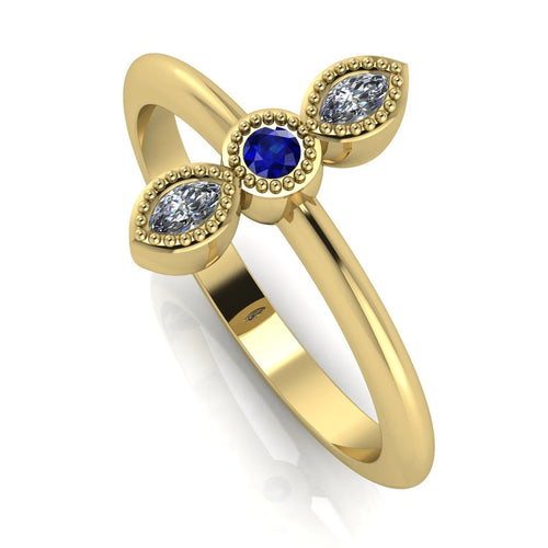 Angled perspective of an 18ct yellow gold trilogy ring with a sapphire and diamonds featuring fine milgrain textured edges.