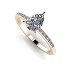 Front three-quarter studio view of the Calista diamond ring, highlighting the row of white pavé diamonds set beautifully into the warm rose gold shoulders. Reflective background.