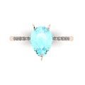 Top-down studio hero shot of the Calista engagement ring, featuring a vibrant 2-carat pear-shaped aquamarine on a polished 18ct rose gold band with sparkling diamond shoulders.