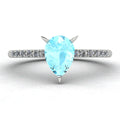 Front three-quarter studio view of the Calista aquamarine ring, highlighting the brilliant white pavé diamonds set into the polished white metal shoulders.