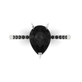 Top-down studio hero shot of the Calista engagement ring, featuring a massive pear-shaped black diamond framed by a dainty black diamond band.