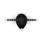 Top-down studio hero shot of the Calista engagement ring, featuring a massive pear-shaped black diamond framed by a dainty black diamond band.