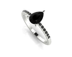 Front three-quarter studio view of the Calista ring, highlighting the brilliant white accent diamonds framing the central black pear diamond.