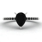 Front studio hero shot of the Calista ring, showcasing a striking pear-shaped black diamond on a band with pave-set white diamond shoulders.