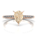 Front studio hero shot of the Calista ring, showcasing a prominent pear-shaped champagne diamond on a rose gold band with white diamond shoulders.