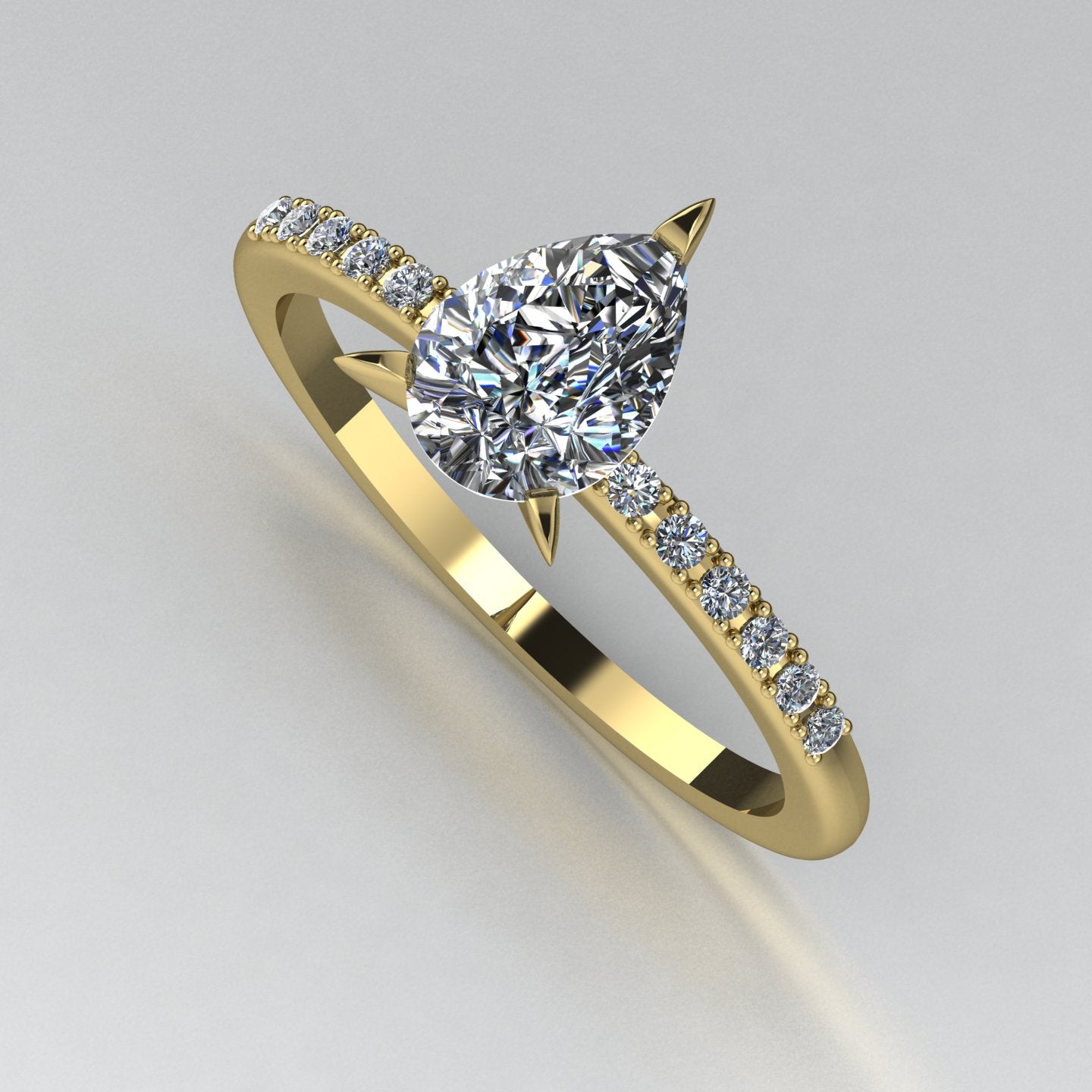 High angle studio detail shot of the Calista alternative engagement ring, showing the exceptional clarity and light reflection within the yellow gold diamond ring. Shaded background.