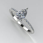 Front three-quarter studio view of the Calista diamond ring, highlighting the row of white pavé diamonds set smoothly into the precious white metal shoulders. Tonal background.