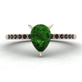 Top-down studio hero shot of the Calista engagement ring, featuring a vibrant pear-shaped green tourmaline on a rose gold band with black diamond shoulders.