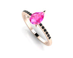Front three-quarter studio view of the Calista pink sapphire ring, highlighting the moody, edgy contrast of the black diamonds set into the rose gold shoulders.