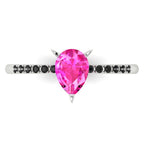 High angle studio detail shot of the Calista alternative engagement ring, showing the bright pink clarity of the sapphire facets against the dark shoulder stones.