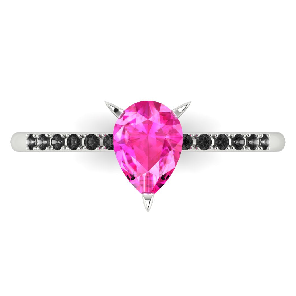 High angle studio detail shot of the Calista alternative engagement ring, showing the bright pink clarity of the sapphire facets against the dark shoulder stones.