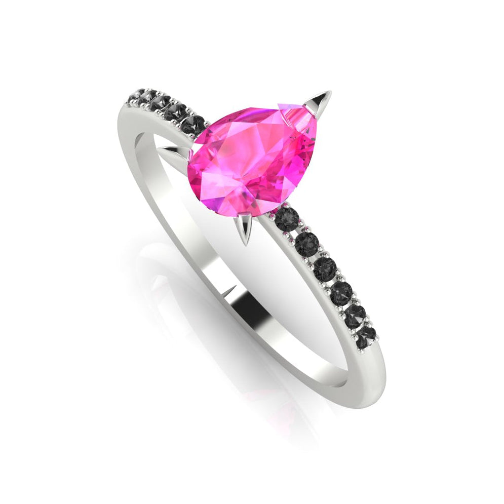 Front three-quarter studio view of the Calista pink sapphire ring, highlighting the edgy contrast of the black diamonds set into the polished white gold or platinum shoulders.