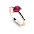 High angle studio detail shot of the Calista alternative bridal ring, highlighting the deep red tones of the ruby facets against the dark shoulder stones.