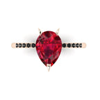 Top-down studio hero shot of the Calista engagement ring, featuring a 2-carat pear-shaped red ruby on a rose gold band set with black diamonds.