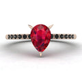Front studio hero shot of the Calista engagement ring, featuring a 0.69ct pear-shaped red ruby on a thin recycled rose gold band with black diamonds.