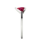 Side profile product photo of the Calista ring, displaying the clean, secure three-prong basket setting holding the pear ruby.