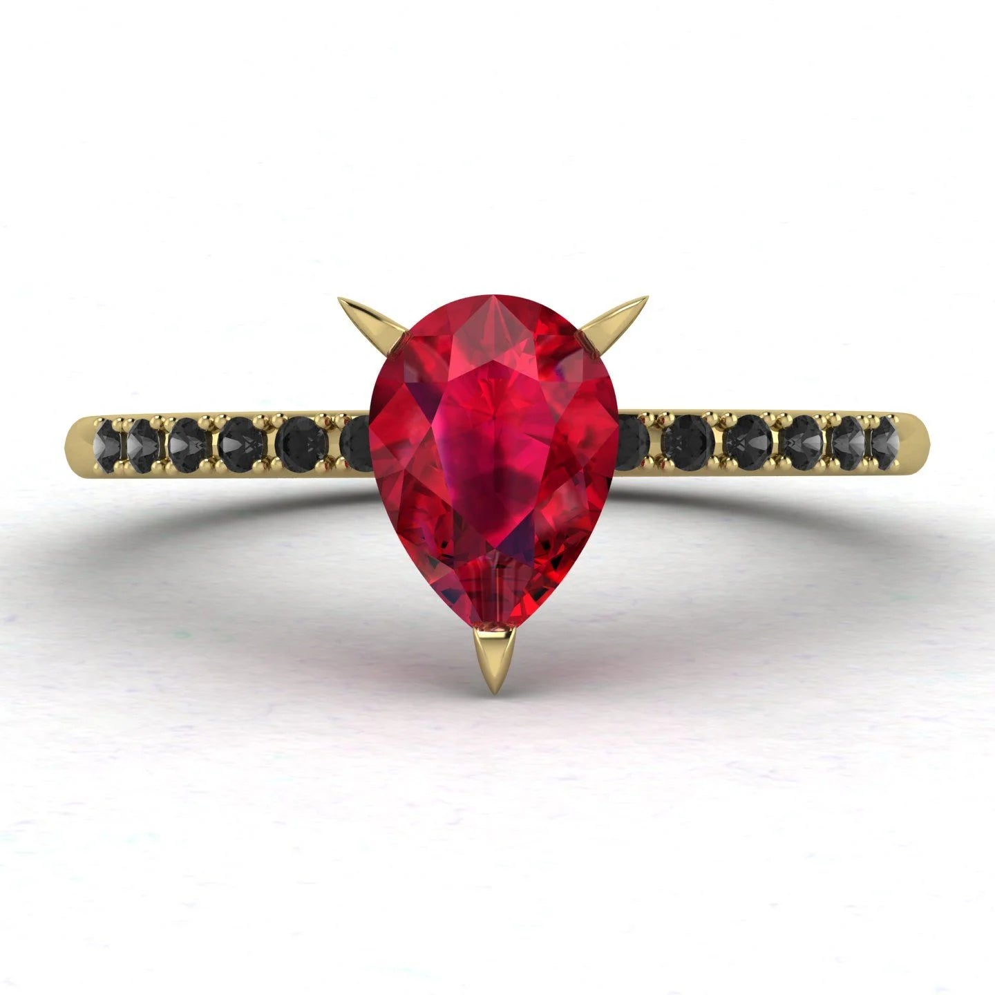 Top-down studio hero shot of the Calista engagement ring, featuring a vibrant pear-shaped red ruby on an 18ct yellow gold band with black diamond shoulders.