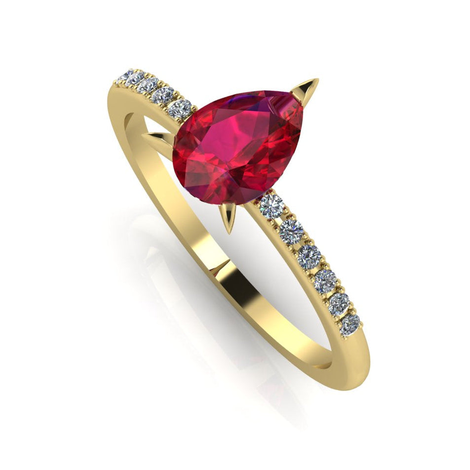 Front three-quarter studio view of the Calista ruby ring, highlighting the brilliant white pavé diamonds set into the warm, rich yellow gold shoulders.