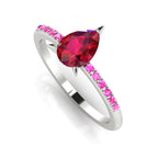 Front three-quarter studio view of the Calista ruby ring, highlighting the beautiful pink-to-crimson gradient of the sapphires set directly into the polished white metal shoulders.