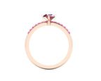 Through-finger view of the 18ct rose gold ring, showing the clean interior under-gallery and precise craftsmanship of the pink sapphire settings.