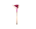 Side profile product photo of the Calista ring, displaying the sleek three-prong basket setting holding the pear-cut ruby.