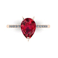 Top-down studio hero shot of the Calista engagement ring, showcasing a prominent 2-carat pear-shaped red ruby on a polished rose gold band.