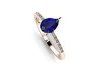 Front three-quarter studio view of the Calista sapphire ring, highlighting the brilliant white pavé diamonds set directly into the warm rose gold shoulders.