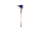 Side profile product photo of the Calista ring, displaying the elegant, secure three-prong basket setting holding the pear-cut blue sapphire.