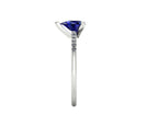 Side profile product photo of the Calista ring, displaying the clean, secure three-prong claw basket setting holding the pear-cut blue sapphire.